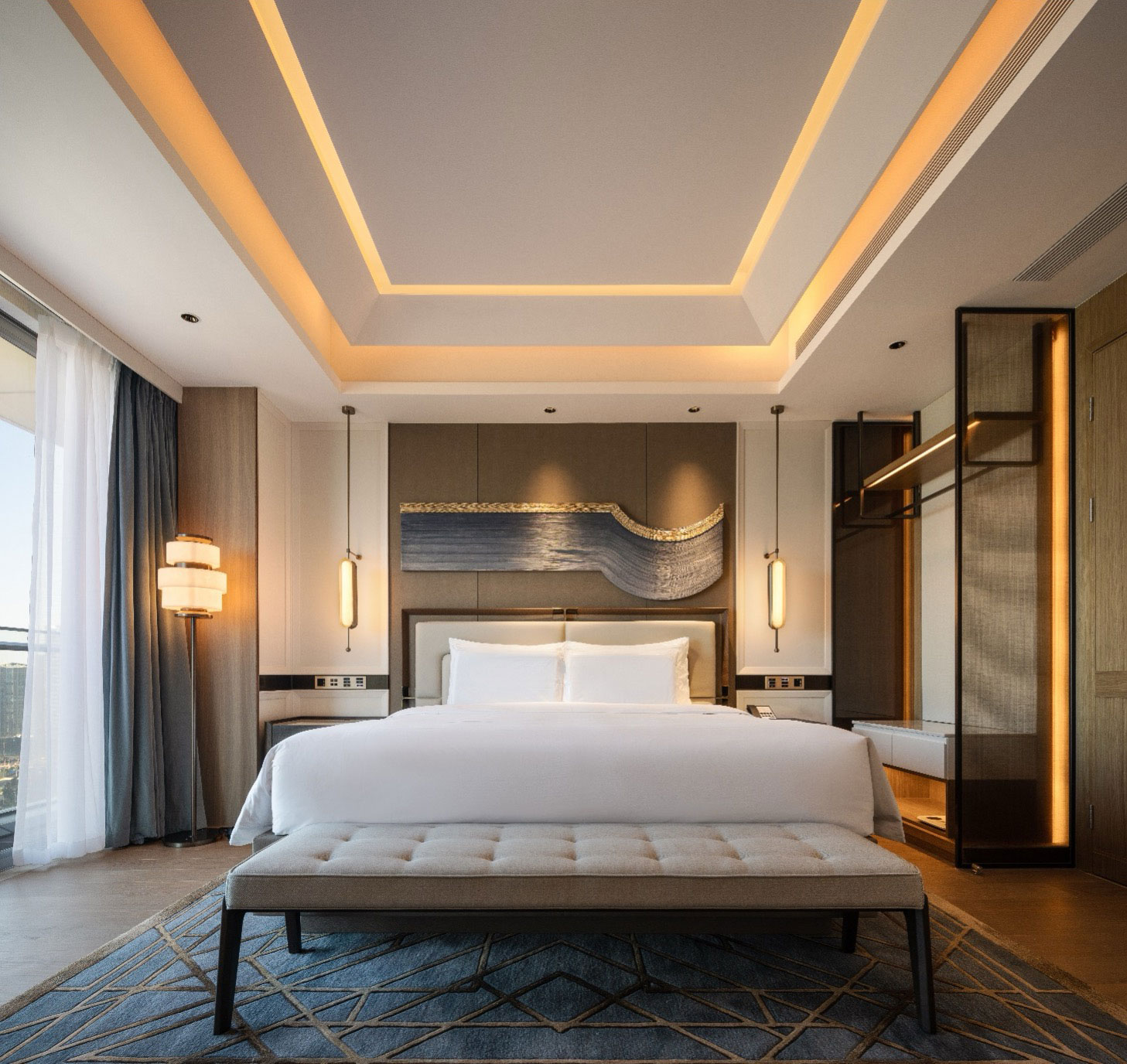 Elegant hotel room with a plush king-size bed, artistic wall decor, ambient lighting, and a modern ceiling design, conveying luxury and calmness.