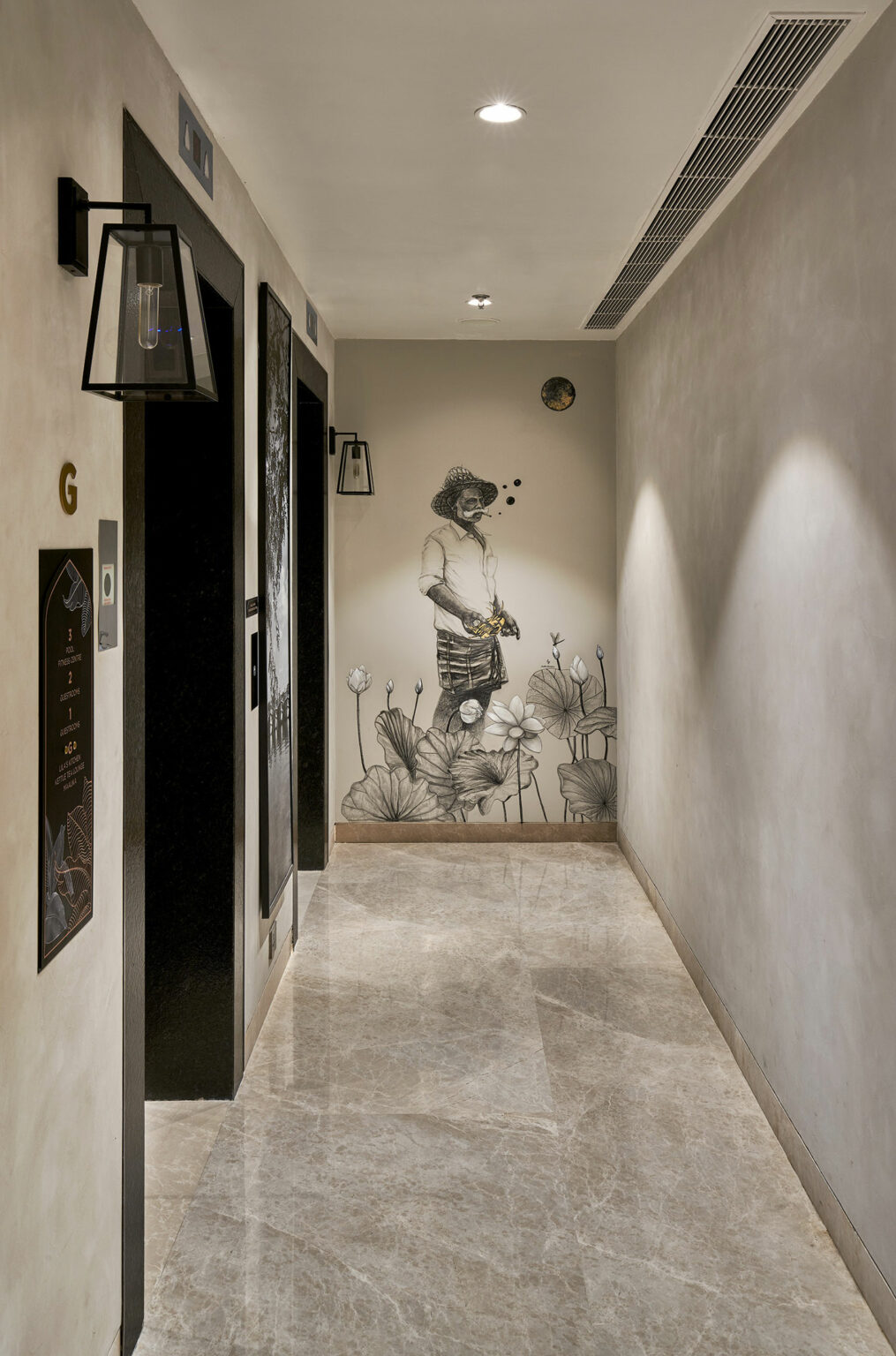 Hallway with marble floor, black elevator doors on left, floral mural of a person holding yellow flowers on the end wall, creating a serene atmosphere.