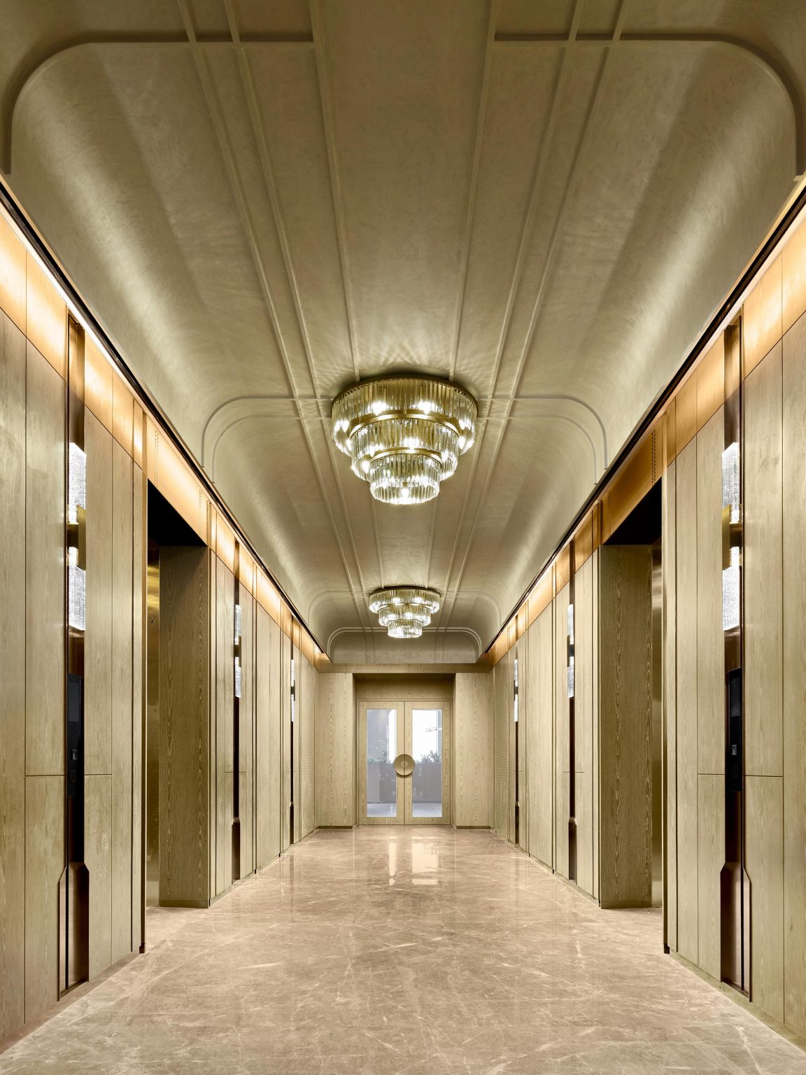 Elegant hallway with a luxurious marble floor, mirrored walls, and ornate chandeliers. The space feels grand and sophisticated, leading to a distant door.