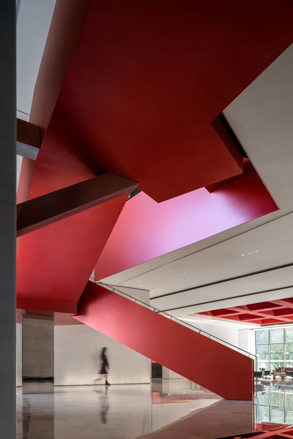 A modern interior featuring a striking red staircase against a minimalist background.