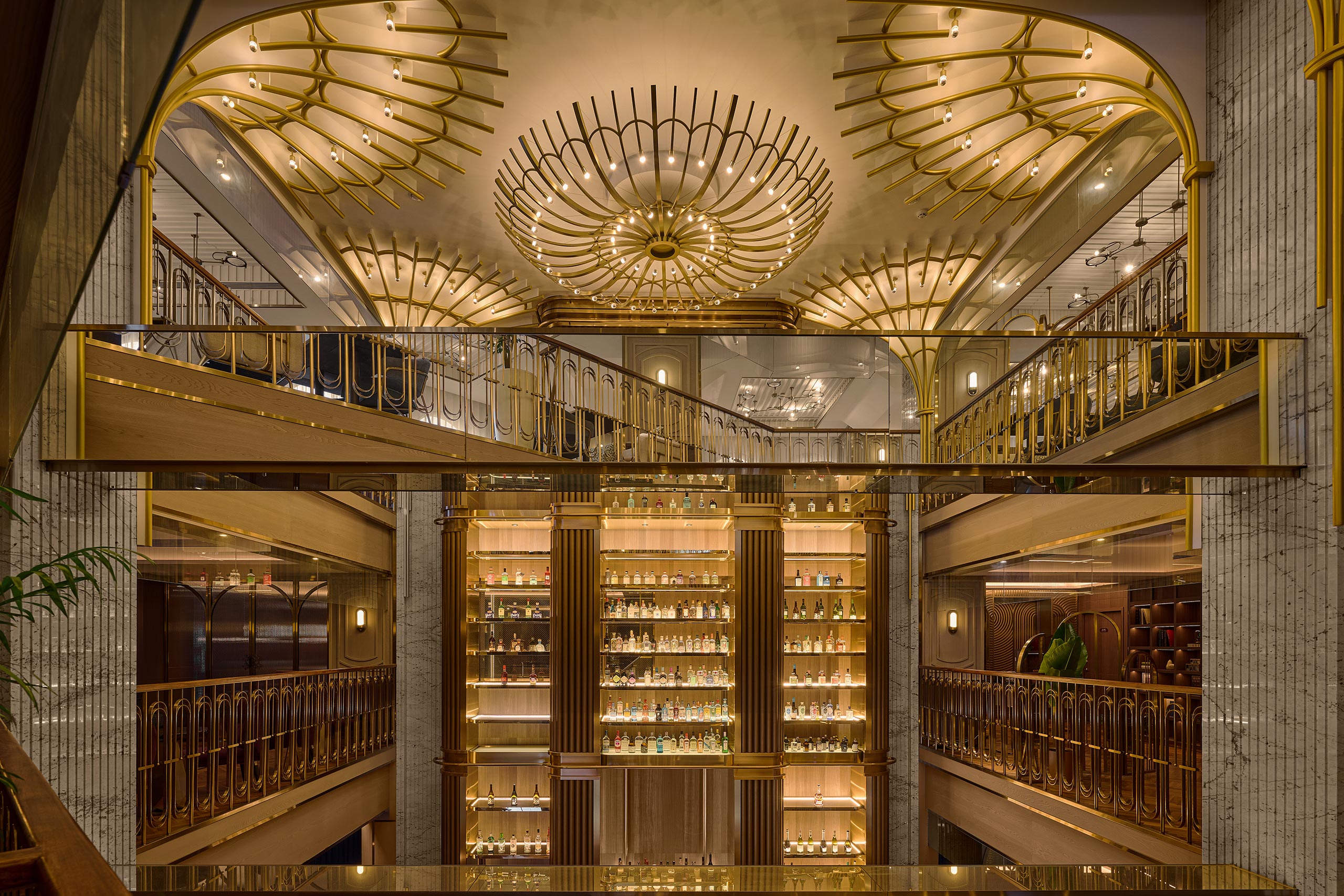 Opulent Art Deco hotel interior with gold railings, glowing chandeliers, mirrored balconies, and illuminated liquor shelves creating a glamorous mood.