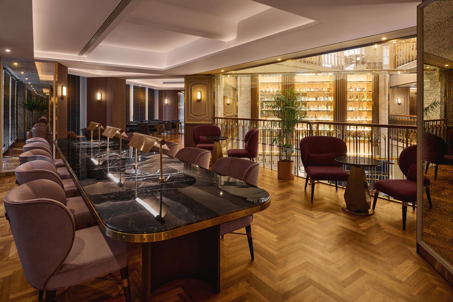 Elegant upscale cocktail lounge with marble tables, velvet chairs, warm lighting, wood floors, and a glowing backlit bar creating a refined mood.